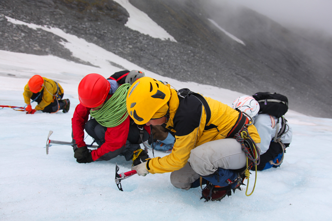 туристы в снаряжении на леднике