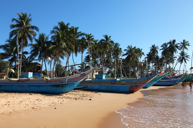 Рыбацкие лодки на берегу океана в Хиккадуве, Шри Ланка
