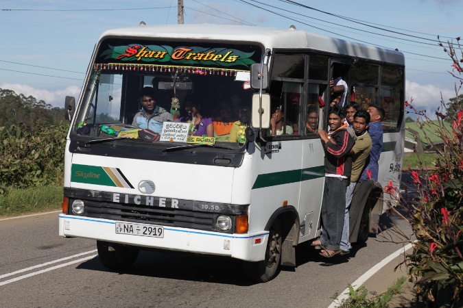 люди висят на подножке пригородного автобуса Шри-Ланка